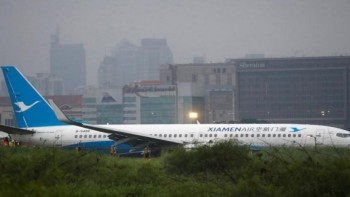 Xiamen Air passenger jet skids off runway in Manila in torential rain